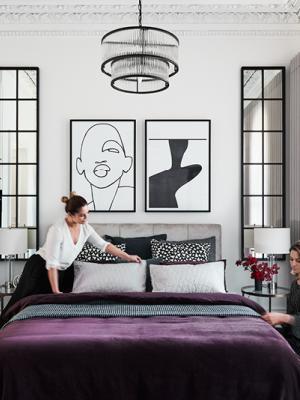 Bedroom in white and grey with graphic art.